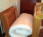 una mesa desmontada, un colchón-futón  y un soporte