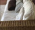 Un sofá de mimbre con sus cojines.